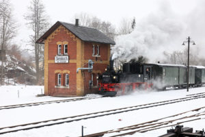 Dampflok 99 1594-3 am historischen Bahnhofsgebäude Steinbach bei Jöhstadt mit Wasserkran im Winterbetrieb